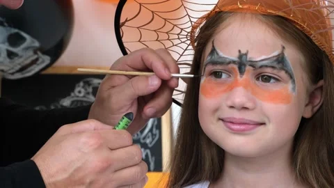 Dad draws aqua makeup on kid girl face for Halloween. Happy family Stock Footage 247423176