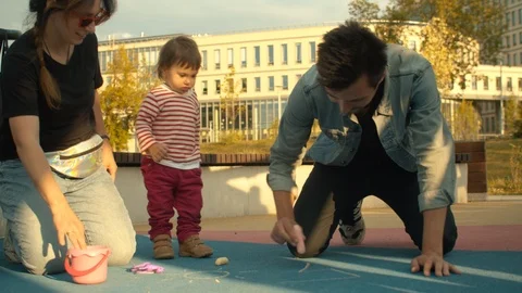 Dad draws with chalks on the playground Video stock 112400979