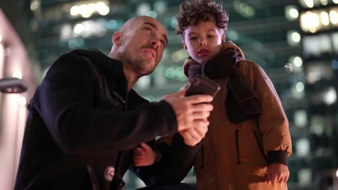 Dad is explaining to his little son about megapolis and buildings around, father Video stock 166936551