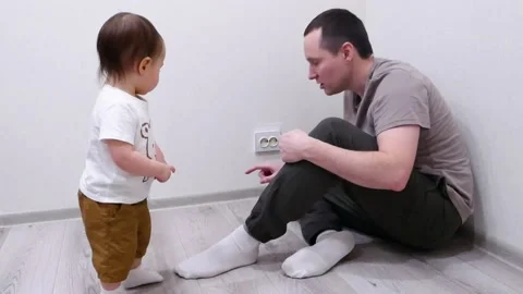 Dad explains to the child that it is dangerous to touch the sockets Stock Footage 191458910