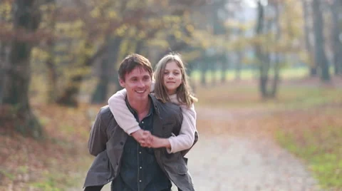 Dad gives daughter piggyback ride Stock Footage 59554206