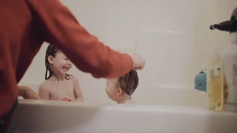 Dad giving his two young daughters a bath. Stock Footage 130087419
