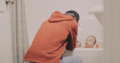 Dad giving his two young daughters a bath. Stock Footage 130087453