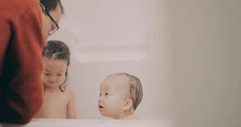 Dad giving his two young daughters a bath. Stock Footage 130087518