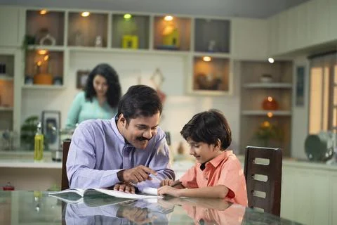 Dad Helping Son In Doing School Homework Stock Photos
