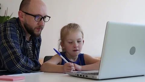 Dad helps daughter do homework from online school. Stock Footage 244008034