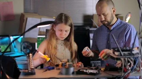 Dad Helps Daughters Collect an Electronic Device in the Home Lab. Stock Footage 95226499