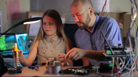 Dad Helps Daughters Collect an Electronic Device in the Home Lab. Slow Motion Stock Footage 95226510