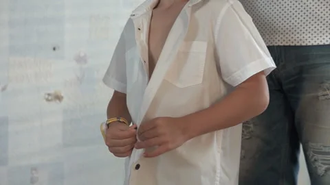 Dad helps his child put on a white shirt Stock Footage 115357579