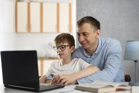 Dad helps his son do homework. Boy is doing homework with his father. Dad tea Stock Photos