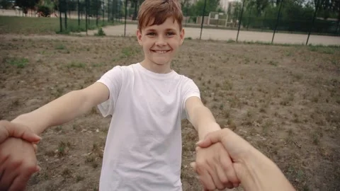 Dad holding hands spinning happy smiling cute son playing together in nature. Stock Footage 196720439