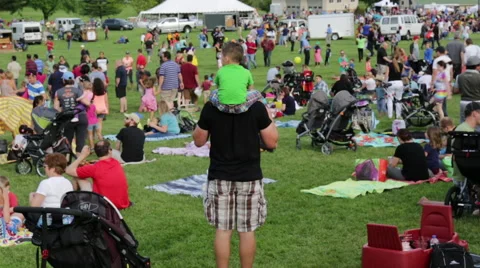 Dad with kid on shoulders in a large crowd at a Hot Air Balloon Festival Stock Footage 64821864