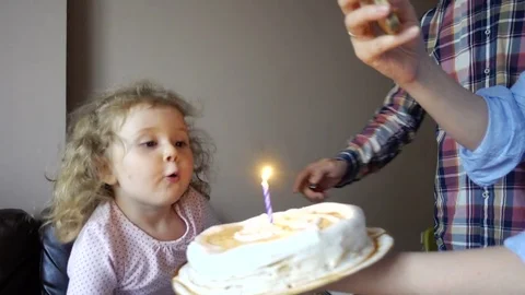 Dad lights a candle on cake for a one-year-old son Stock Footage 76380435