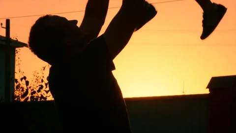 Dad playing with his son on the backyard at sunset Stock Footage 75187320