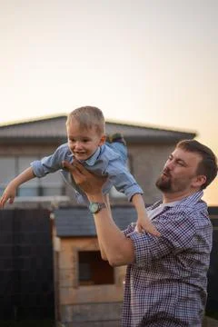 Dad playing with his son in the backyard of the house Stock Photos