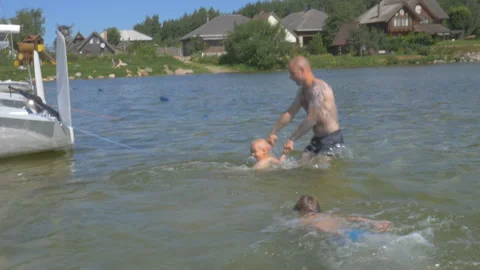 Dad playing with two boy in the river slow motion Видео 155389362