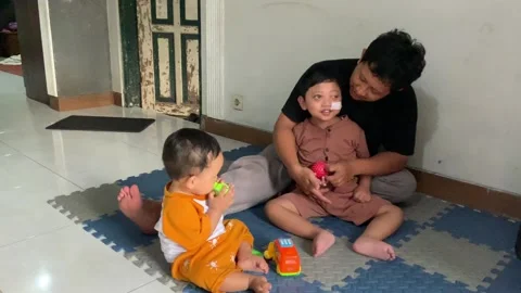 Dad is playing using a tactile ball with a child living with cerebral palsy and  Stock Footage 326845013