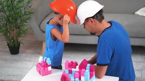 Dad plays in rams with son in construction helmets with constructors cubes game Video stock 131834875