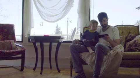 Dad points out thing on cell phone to child Video stock 64382556