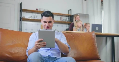 Dad resting while mom looking after children Stock Footage 116334390