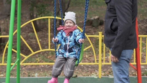 Dad rolls a small daughter on a swing. Stock Footage 95830830
