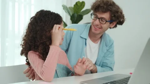 Dad show thumb while daughter put pencil on ear and explain prompt. Pedagogy. Stock Footage 279682186