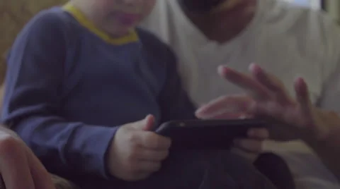 Dad shows cute son how to swipe on phone Stock Footage 64401894