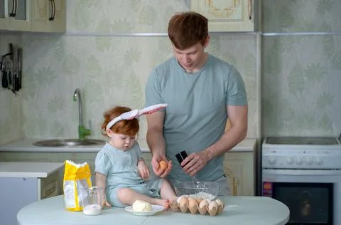 Dad with a small child is preparing an Easter cake Stock Photos