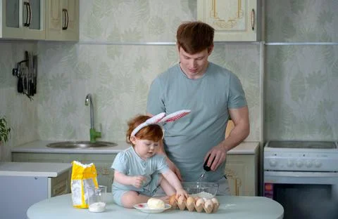 Dad with a small child is preparing an Easter cake Stock Photos