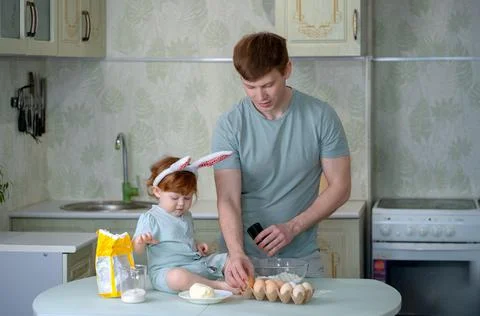 Dad with a small child is preparing an Easter cake Stock Photos