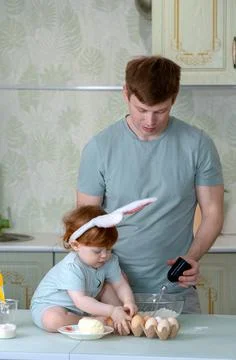 Dad with a small child is preparing an Easter cake Stock Photos