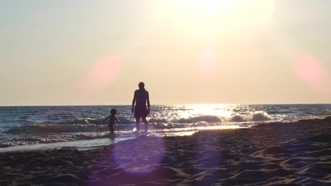 Dad, with son on the beach having fun at sunset, multinational father playing Stock Footage 130228974