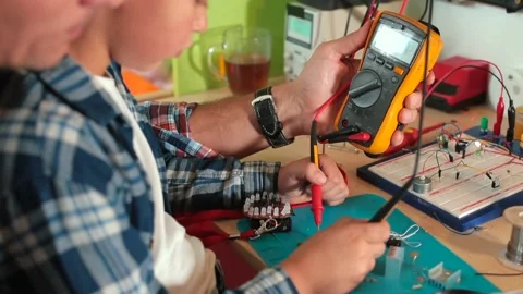 Dad son checking electrical equipment test conductivity electricity using device Видео 153841517