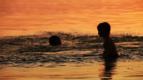 Dad with son fooling around in ocean sunset waves Stock-Footage 27294749