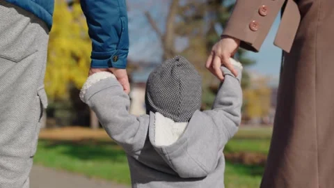 Dad, son, mom and hold hands on sidewalk in city in sun. Family vacation Stock Footage 214522692