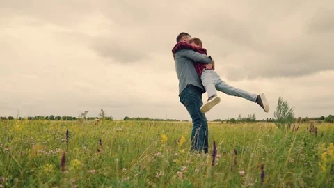 Dad swings son in open field, boy imagines flying high, parent and child create Stock Footage 312725708