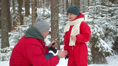 Dad takes off his gloves from his son warms his hands Stock Footage 129096338