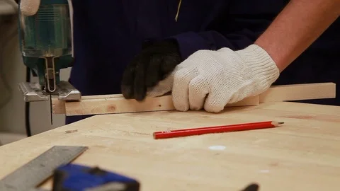 Dad teaches the boy to work with an electric jigsaw, close-up hands in working g Vidéo 102240284