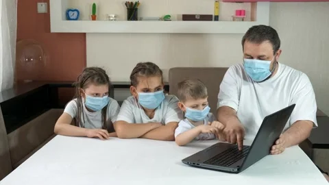 Dad teaches children how to use a laptop indoors. Social distancing 動画素材 130180183