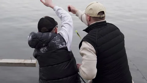 Dad teaches his son how to catch predatory fish in the river. Stock Footage 309921057