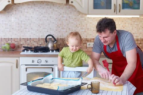 Dad teaches the small child to preparing baking cookies or pastries together Stock Photos