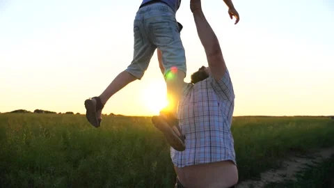 Dad throwing up his cheerful son at countryside. Father and child have fun Video stock 311379731