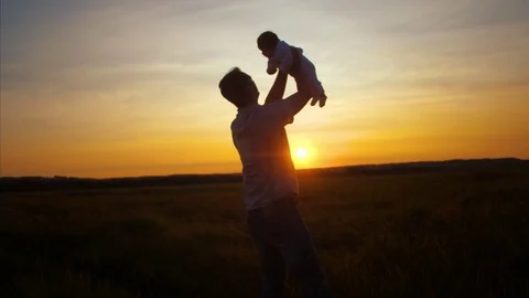 Dad throws child at sunset of golden sun. Slow motion. Video stock 81095466