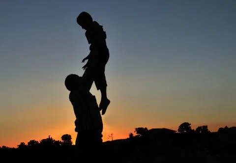 Dad throws the child at sunset Stock Photos