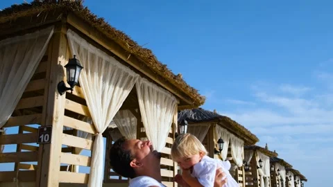 Dad tosses his son up at a beach resort Stock Footage 234470239