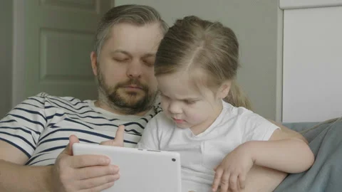 Dad tries not to sleep while playing with his daughter. Funny games app. 库存影片 131941795