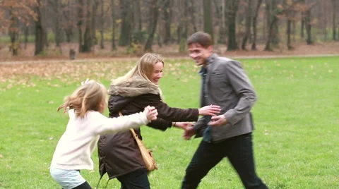 Dad trying to catch daughter while she's hiding behind mom Stock Footage 59554465