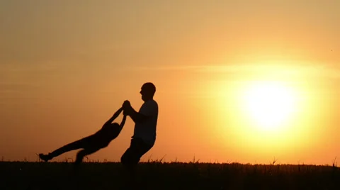 Dad turns in a circle of his son at sunset on nature Stock Footage 29985405