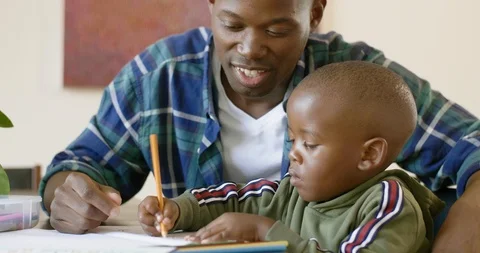 Dad watching his son drawing coloring books Stock Footage 119612708