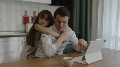 Dad works remotely with a computer at the dining table in the kitchen. Stock Footage 201337986
